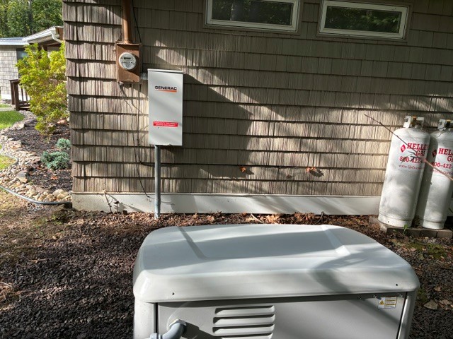 Generac standby generator with propane hookup beside a home
